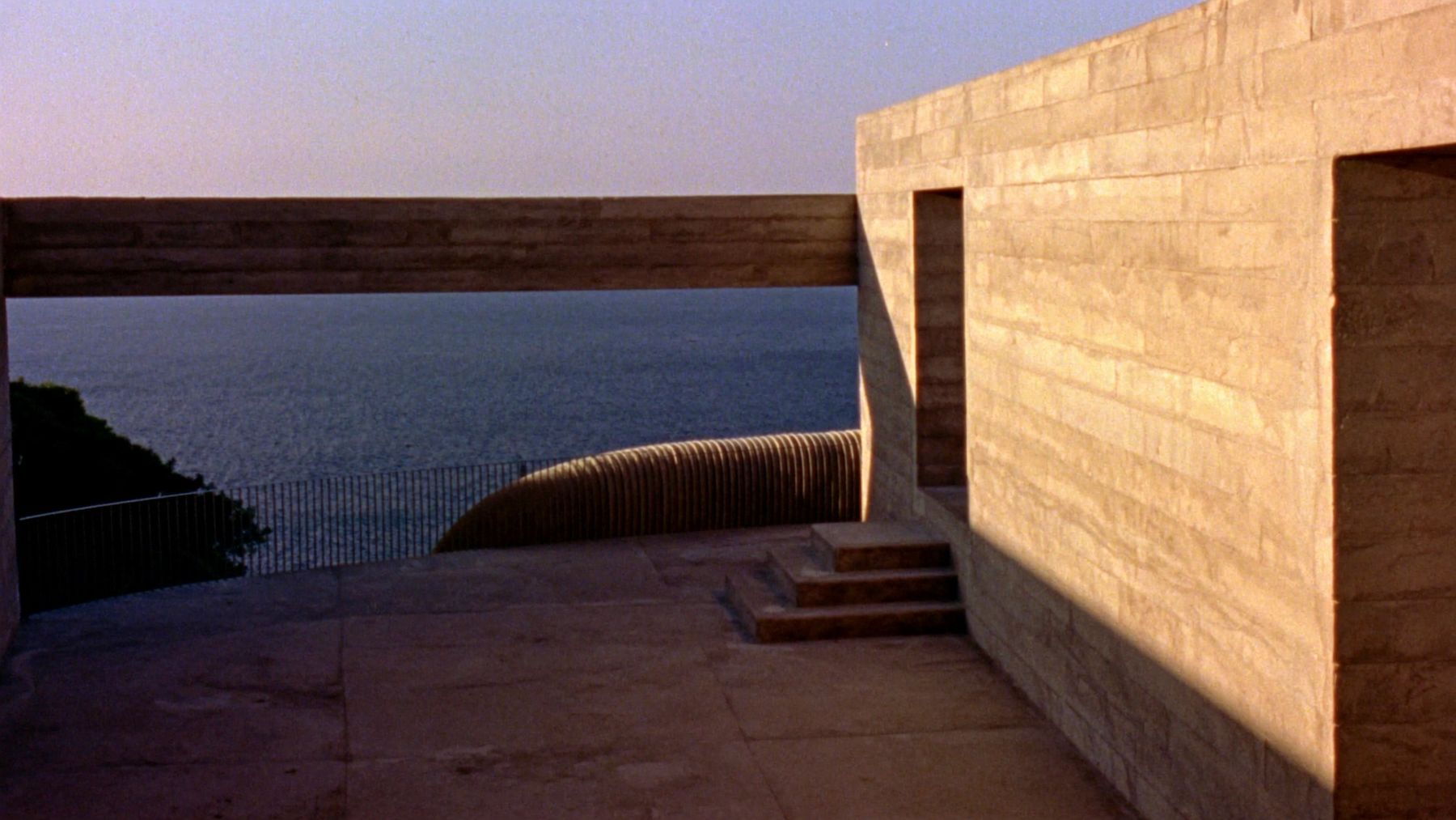 Location plate: concrete terrace above the sea at sunset